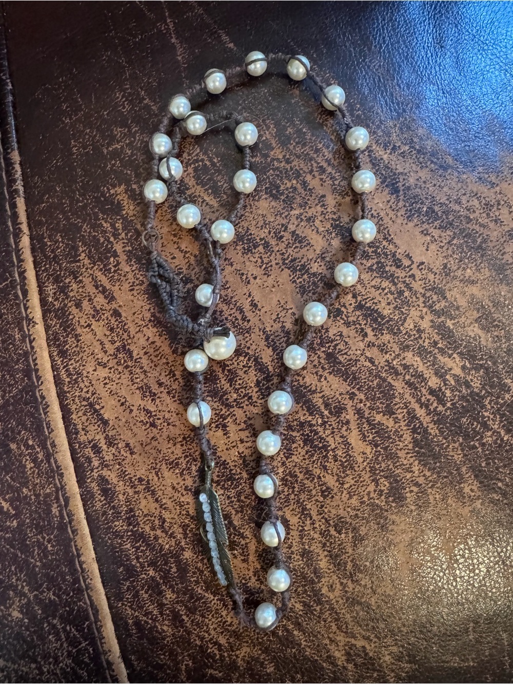 A Rare Bird Handknotted Pearl Necklace in Cream on Brown Cord